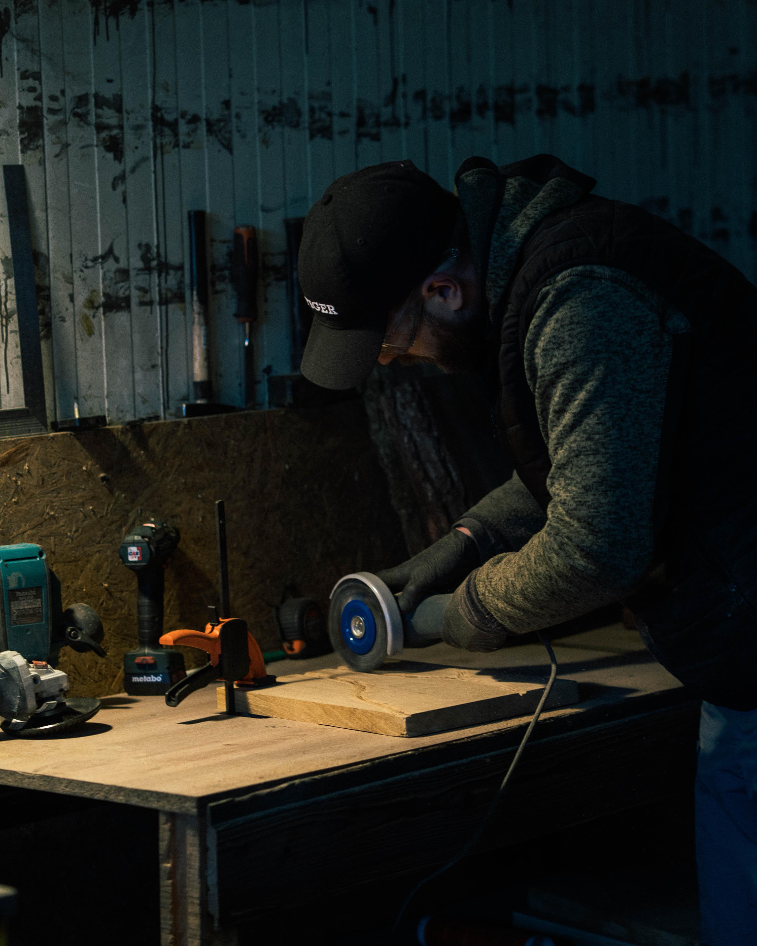 Hands brushing and finishing a charred board in the workshop