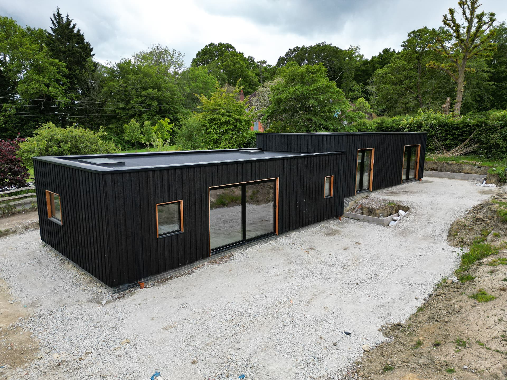 Flat-roofed modern dwelling house in East Sussex clad in vertical KAEN Carbon charred larch