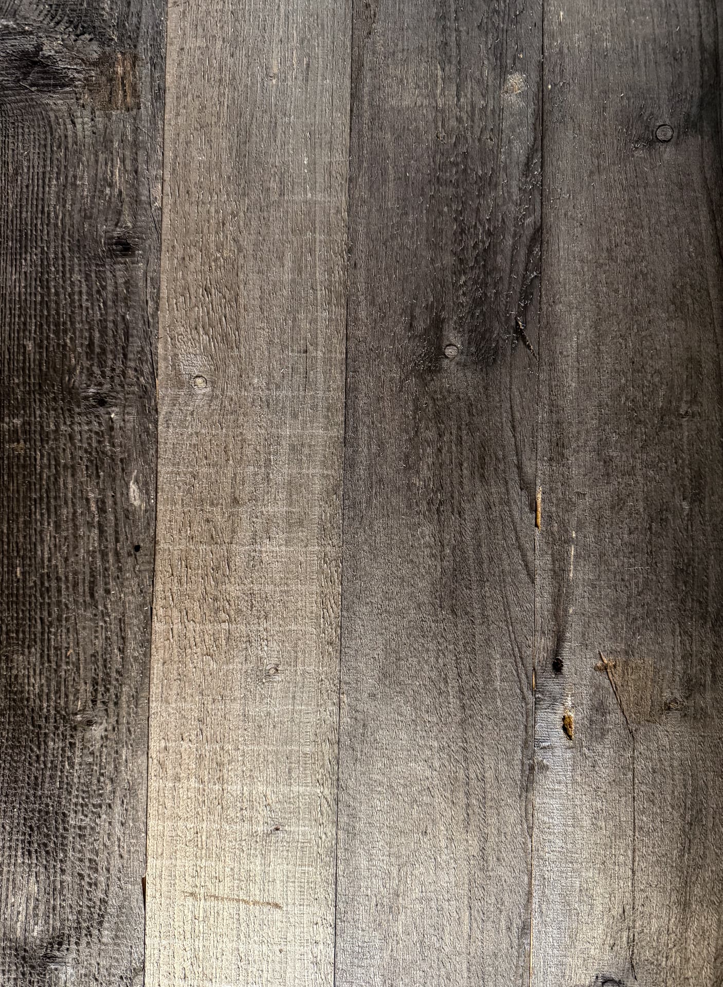 Close view of naturally weathered reclaimed timber with original grain, fixing marks and tonal variation